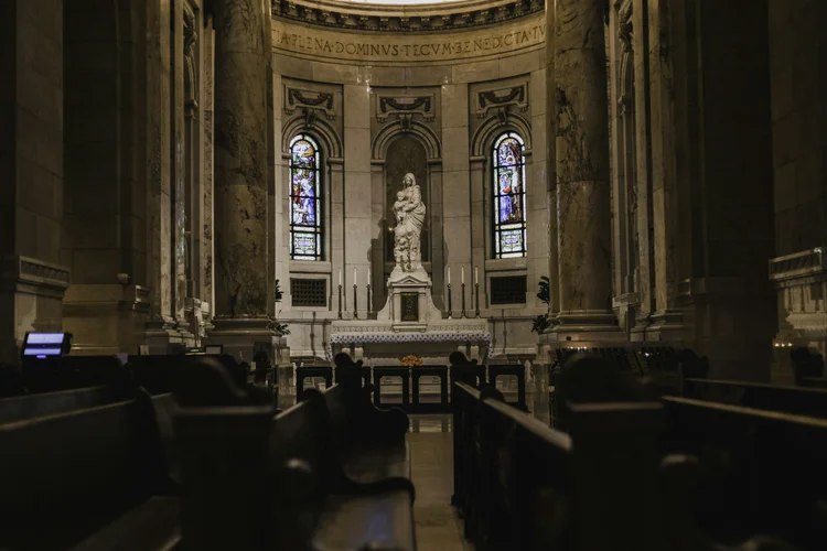 Candlelit church interior with stained glass and stone columns
